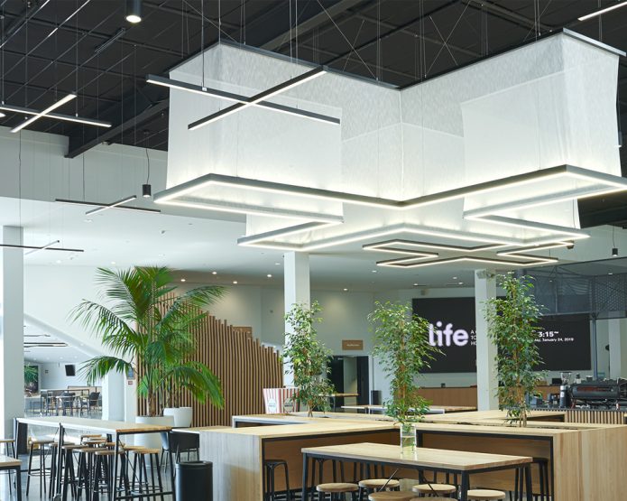 An interior image of a cafe with lighting on the roof in the shape of an X
