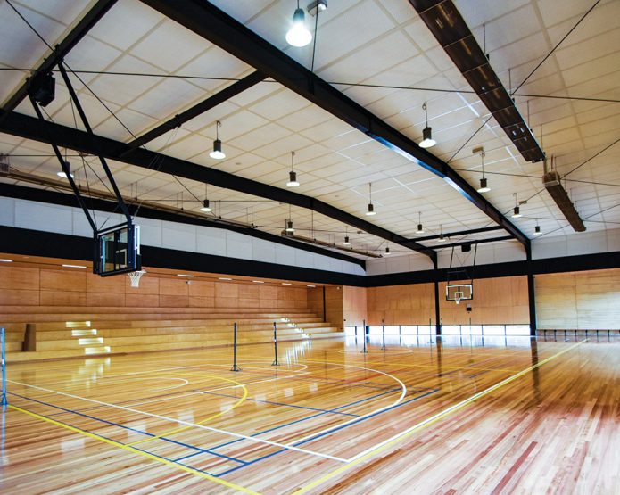 Compressed straw ceiling panel used in a school gymnasium